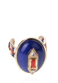 Bague en pierre bleue avec des éléments en or, dotée d'une pierre précieuse rouge rectangulaire et d'accents clairs. L'anneau est tissé de perles colorées.