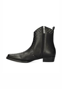 Bota de tobillo de cuero negro con acentos de tachuelas, punta afilada y cremallera lateral. Presenta un acabado texturizado y un tacón bajo apilado.