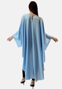 Ljusblå satincape med breda ärmar och detalj med nyckelhål i ryggen. Tyget är slätt, med en flödande drape och avslappnad passform.