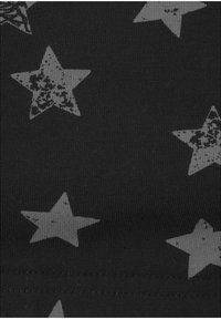 Tela negra con patrones de estrellas grises dispersas y un acabado texturizado. Las estrellas varían en tamaño y diseño, creando un efecto visual contrastante.