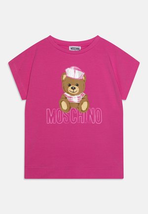 Camiseta rosa brillante con un osito de peluche que lleva un sombrero y camisa de marinero rosa y blancos, con la palabra "MOSCHINO" debajo.