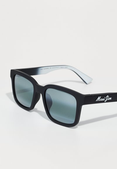 Ochelari de soare rectangolari negri cu lentile tentate. Fața are o finisare mată, în timp ce bratele au o strălucire ușoară cu un logo. Fabricat în Japonia.