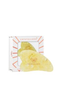 Żółte kryształowe narzędzie do twarzy o gładkim, zakrzywionym kształcie, zapakowane w białe pudełko z różowymi akcentami i logo "CRYSTALLOVE."