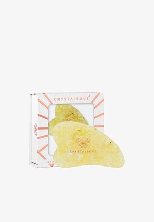 Strumento per il viso in cristallo giallo con forma liscia e curva, confezionato in una scatola bianca con dettagli rosa e il logo "CRYSTALLOVE."