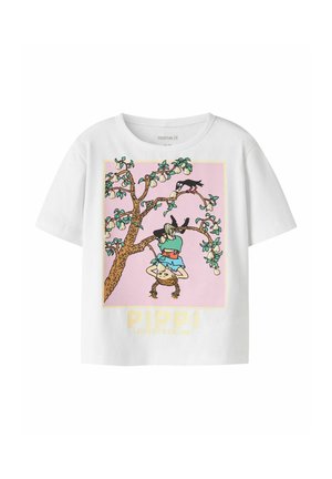 Biały T-shirt z ilustracją dziewczynki wiszącej do góry nogami na gałęzi drzewa oraz czarnego ptaka w pobliżu na jasnoróżowym tle.