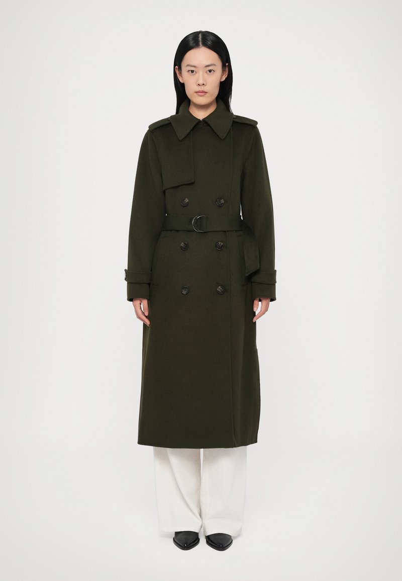 Dubbelgeknoopte, lange olijfgroene jas met een ceintuur in de taille, grote kraag en voorzakken, gemaakt van een gestructureerde stof.