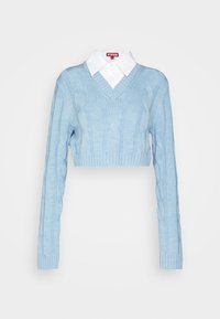 Pull court bleu clair en maille torsadée, superposé sur une chemise blanche à col, manches longues et col en V.