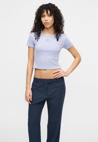 Ανοιχτό μωβ κοντομάνικη μπλούζα cropped με κεντημένο λογότυπο, συνδυασμένη με ναυτικά παντελόνια σε tailored γραμμή που έχουν δύο πλαϊνές τσέπες.