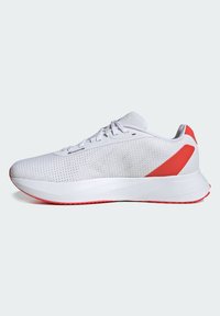Zapatilla de running ligera con una parte superior de malla blanca, acentos rojos en el talón y la mediasuela, y una suela de goma texturizada para agarre.