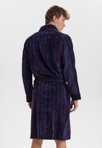 Accappatoio a strisce blu navy e rosso realizzato in morbido tessuto, con maniche lunghe, cintura in vita e collo scialle.