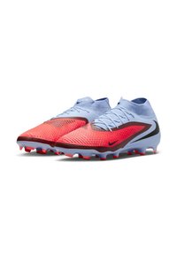 O pereche de ghete de fotbal ușoare cu vârfuri texturate roșii, coliere albastre pentru gleznă și logo-uri negre Nike Swoosh, inclinate spre dreapta pe fundal alb.