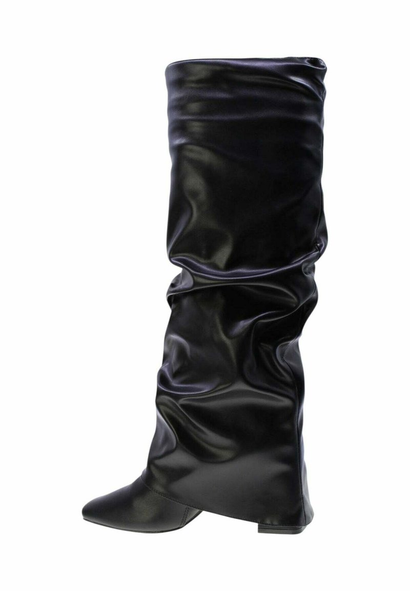 Stivale in pelle nero slouchy, alto fino al ginocchio, con punta affilata e tacco basso, isolato su sfondo bianco.