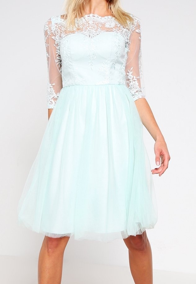 Světle mátově zelené šaty s přiléhajícím korzetem, průhlednými krajkovými rukávy a rozšířenou tylovou sukní. Složitá květinová výšivka kolem výstřihu.