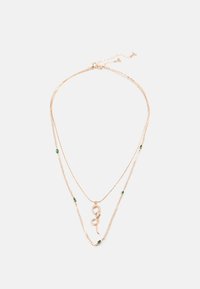 Guldtonet lagdelt halskæde med en slangependant prydet med grønne accenter, delikat kædedesign og små detaljer, der ligner emeralds.