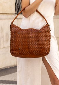 Borsa a tracolla in pelle intrecciata marrone dalla forma arrotondata, con accenti metallici e una sola tracolla. Design testurizzato e flessibile.
