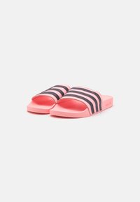 Ružové šľapky so štruktúrovanou stielkou, zdobené vedúcimi tromi čiernymi horizontálnymi pruhmi. Vyrobené zo syntetického materiálu.