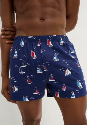 Boxer navy in cotone con stampa di vela e gabbiano, dotati di un elastico in vita e chiusura con un singolo bottone.