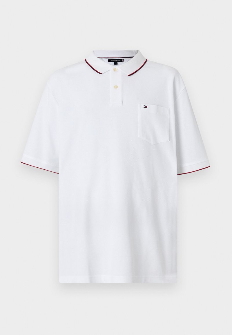 Camisa polo branca com um fecho de dois botões, gola vermelha em contraste e acabamento vermelho nas mangas, e um pequeno bolso no peito com um logotipo.