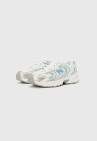 Leichte Sportschuhe in Weiß mit silbernen und hellblauen Akzenten. Sie verfügen über ein Mesh-Obermaterial, eine gepolsterte Sohle und ein traditionelles Schnürdesign.