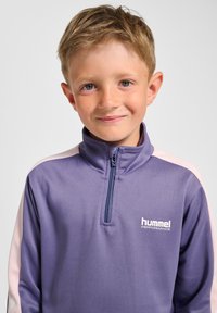 Paarse sweatvest met ritssluiting en roze accenten, voorzien van een hoge kraag en een wit logo op de borst. Gladde, lichtgewicht stoftextuur.