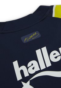 Námořnický sportovní dres s velkým bílým logem "haller", hladká textura a límeček s žlutými akcenty se značkovou etiketou blízko výstřihu.