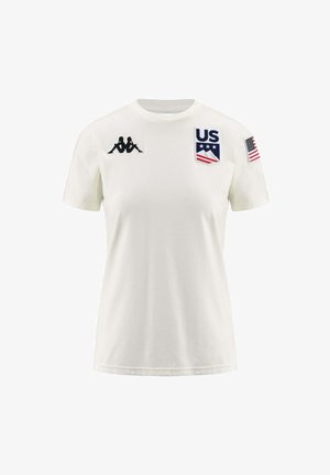 T-shirt bianca in cotone con maniche corte, logo Kappa sul lato sinistro del petto e patch della bandiera statunitense sulla manica destra, con una stampa di emblema multicolore.