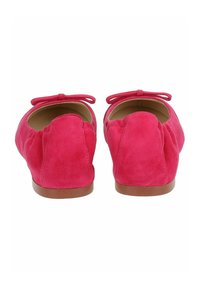 Bailarinas de ante fucsia con punta redondeada, cuello elástico y detalle de lazo decorativo en la parte posterior. Suela plana marrón.