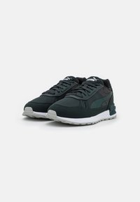Scarpe sportive nere con accenti in rete, suola intermedia bianca e suola in gomma testurizzata. Presenta il logo sulla linguetta e sul lato. Forma generale da sneaker.