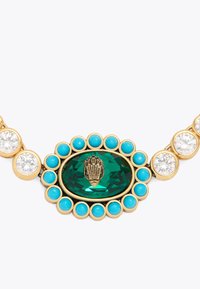 Collana dorata con un centro a gemma verde ovale, circondata da perline turchesi e pietre trasparenti, con un dettaglio decorativo a conchiglia.