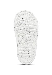 Semelle de chaussure blanche avec des taches noires, motifs de tread circulaires et linéaires, et zone de grip texturée au centre.