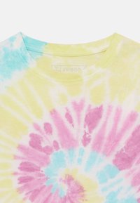 Kurzärmliges Batik-T-Shirt in Gelb-, Pink- und Blautönen. Verfügt über einen runden Ausschnitt und aus weichem, strukturiertem Baumwollmaterial.