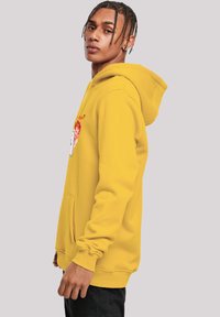 Yellow hoodie with a front pocket, ribbed cuffs, and a drawstring hood. Features an embroidered graphic on the chest. Flat texture.