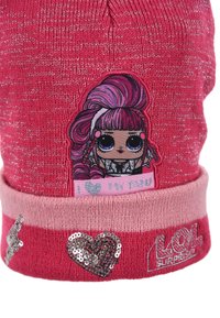 Gorra de punto rosa con hilos brillantes, que incluye un parche de una muñeca, el texto "Amo a mi fan" y acentos de corazón y logo con lentejuelas.