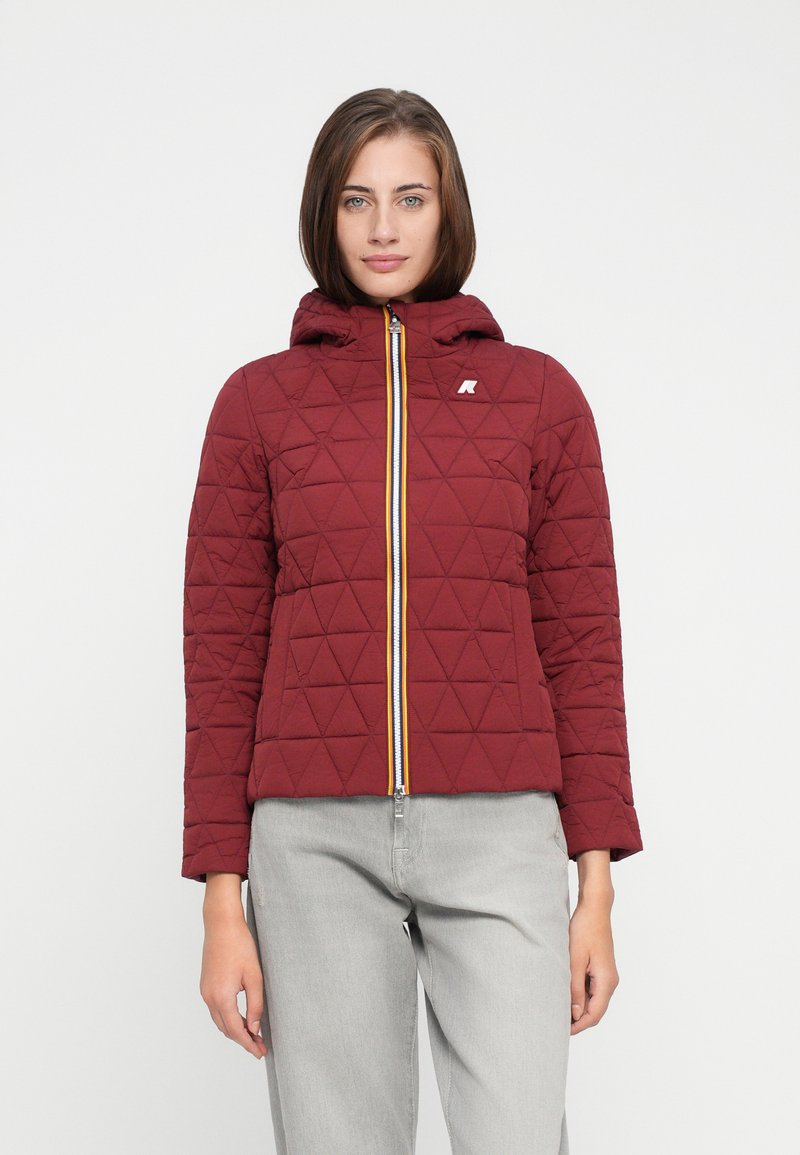Veste matelassée rouge avec une capuche, dotée d'une fermeture éclair à l'avant avec un accent jaune, de motifs en losange et d'un logo sur le côté gauche.