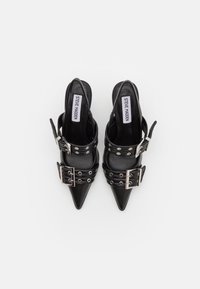 Escarpins slingback noirs à bout pointu avec larges brides à boucle et détails d'œillets argentés, vus de dessus.