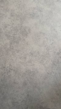 Rupja, pelēka grīda ar pleķainu virsmas rakstu. Materiāls izskatās gluds ar smalkām toņu variācijām.
