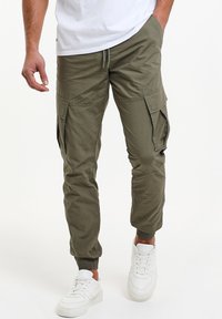 Olivgrön cargo-byxor med elastiska muddar, flera sidofickor och dragsko i midjan. Tillverkade av lätt, texturerad tyg.