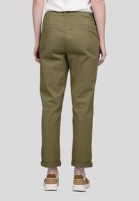 Pantalon droit vert olive avec une taille élastique, des ourlets repliés et des poches arrière. Le matériau en coton offre une texture lisse.