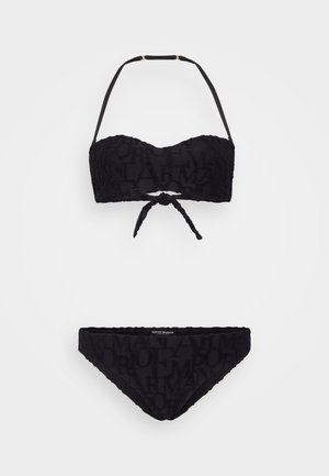 Conjunto de bikini negro que incluye un top bandeau con detalle de lazo y tirantes ajustables, y una parte inferior de bikini de corte bajo con un patrón texturizado de logo.