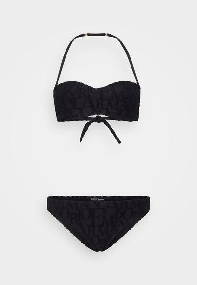 Black bikini set featuring a bandeau top with tie detail and removable straps, and matching low-rise bikini bottom with textured logo pattern.