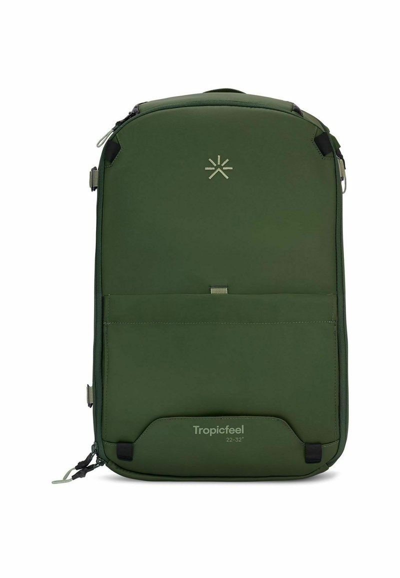 Sac à dos vert avec une texture lisse et mate. Présente un logo sur le devant, des zips et une poche avant pour le rangement. Design compact, forme rectangulaire.