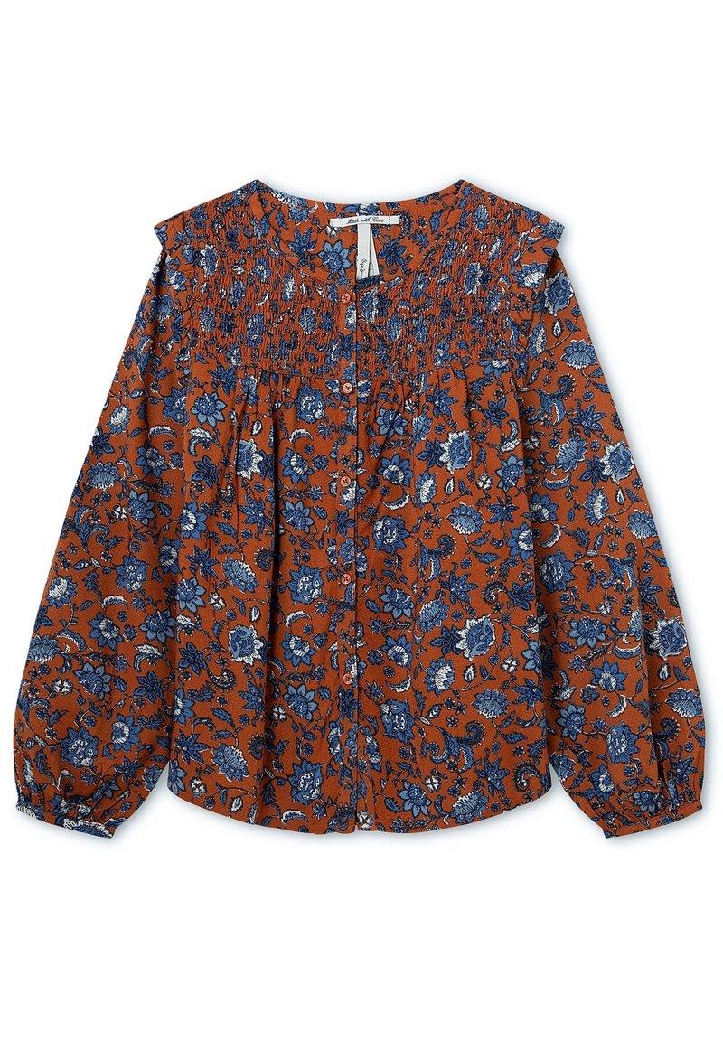 Rustowy top w niebieski wzór kwiatowy, z marszczonym dekoltem i zapięciem na guziki. Długie bufiaste rękawy z elastycznymi mankietami.