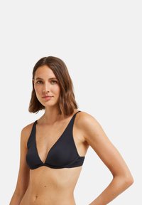 Haut de bikini noir en tissu lisse. Présente un décolleté en V profond, des bretelles larges et des détails froncés au niveau de la poitrine. Design minimaliste.