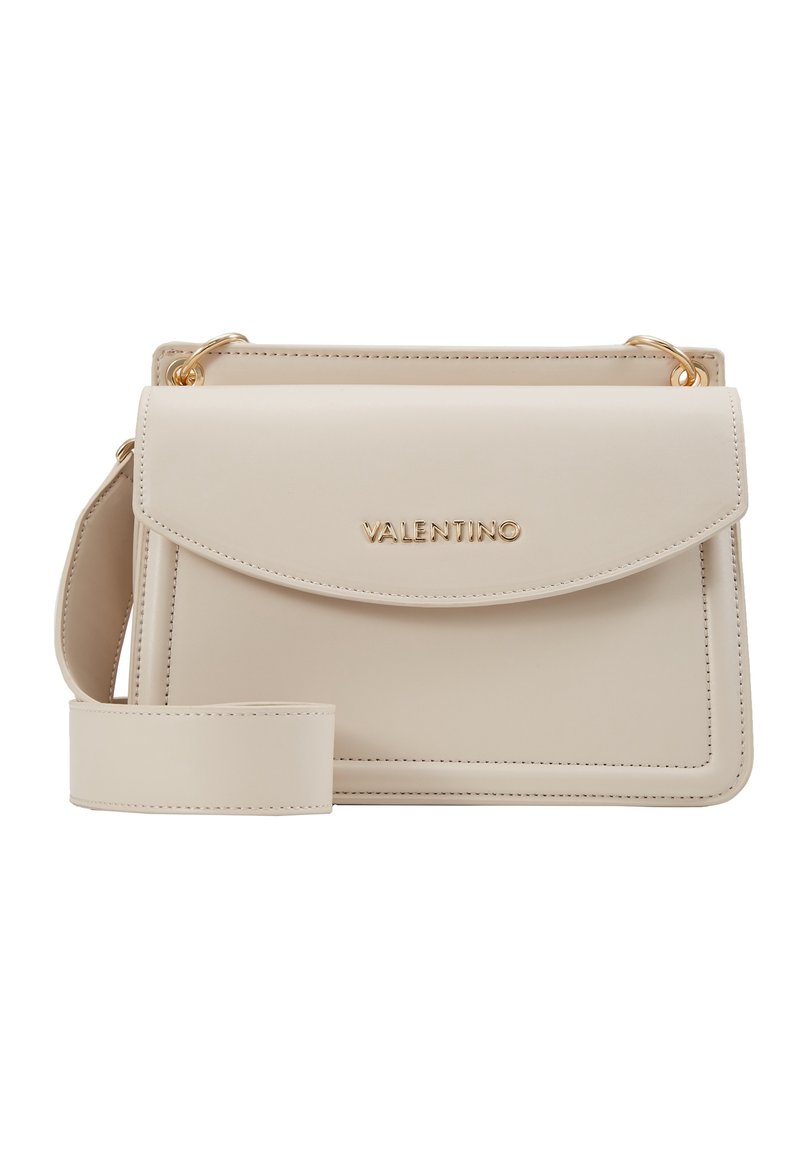 Beige läderhandväska med framfälld stängning och detaljer i guld. Den har en avtagbar rem och präglad logotyp på framsidan.