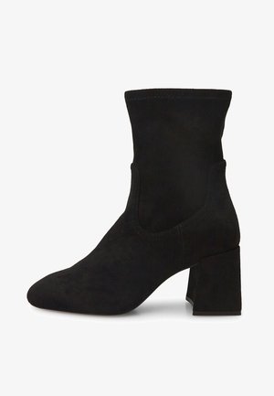 Botas de tobillo de ante negro con punta afilada, caña ajustada y tacón cuadrado grueso. Textura suave sin herrajes o acentos visibles.