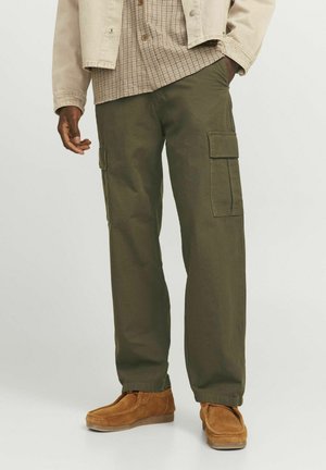 Pantaloni cargo în verde oliv, cu buzunare laterale, croială lejeră și o textură netedă. Asortați cu o cămașă în carouri și încălțăminte maro.