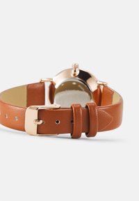 Bracelet de montre en cuir marron avec une finition texturée, équipé d'une boucle en métal doré et d'un cadran de montre rond lisse.