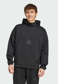Black hooded sweatshirt with a front pocket, made from soft material, featuring a relaxed fit and subtle logo detail on the pocket.
