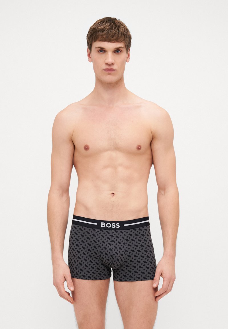 Schwarze Boxershorts mit geometrischem Muster, elastischem Taillengummi mit "BOSS"-Logo, weichem Material und figurbetontem Design.