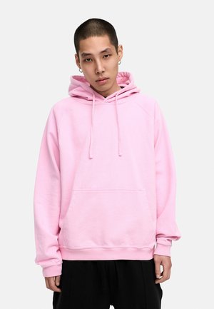 Rosa Sweatshirt mit Kapuze, Kordeln, Kängurutasche und gerippten Bündchen. Weicher Stoff und bequemer Schnitt mit Raglanärmeln.